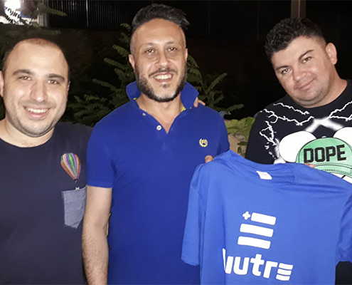 Gruppo di fantallenatori che mostrano la maglia Piutre Fantacalcio azzurra con logo bianco